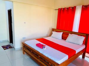 um quarto com uma cama com uma cortina vermelha em Lux Suites Palm Terraces Apartments Nyali em Nyali