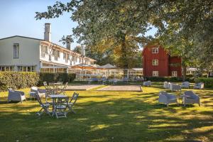 een tuin met een tafel en stoelen en een rode schuur bij Villa Källhagen in Stockholm