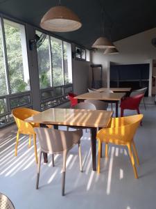 a dining room with tables and chairs and windows at Résidence Bertille Abidjan Cocody in Abidjan