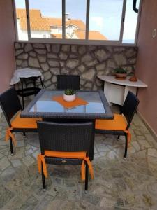 uma mesa e cadeiras num quarto com uma parede de pedra em Apartment Lucia em Omišalj