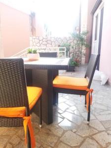 un patio con mesa y 2 sillas en Apartment Lucia en Omišalj