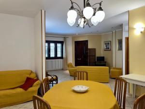 - un salon avec une table et des chaises jaunes dans l'établissement Lupa Di Mare Casa Vacanze, à Otrante