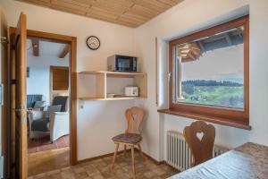 Zimmer mit einem Fenster, einem Stuhl und einem Tisch in der Unterkunft Adlerhorst in Sasbachwalden