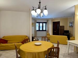 - un salon avec une table et un canapé jaune dans l'établissement Lupa Di Mare Casa Vacanze, à Otrante
