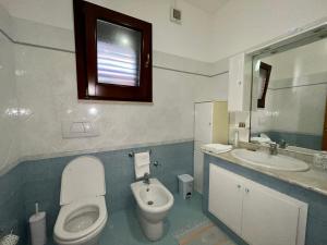 La salle de bains est pourvue de toilettes et d'un lavabo. dans l'établissement Lupa Di Mare Casa Vacanze, à Otrante