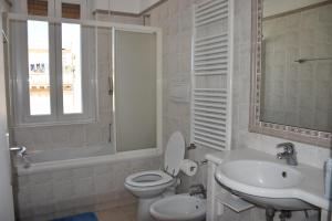 a bathroom with a toilet and a sink and a window at LightHouse - Surfandwindsurferhouse in Anzio +24 photos
