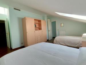a bedroom with two beds and a cabinet in it at Attico Chiavari in Chiavari