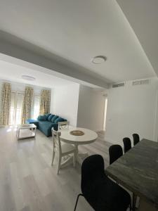 ein Wohnzimmer mit einem Tisch und einem blauen Sofa in der Unterkunft Apartamento Carihuela in Torremolinos