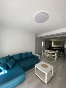 ein Wohnzimmer mit einem blauen Sofa und einem Tisch in der Unterkunft Apartamento Carihuela in Torremolinos