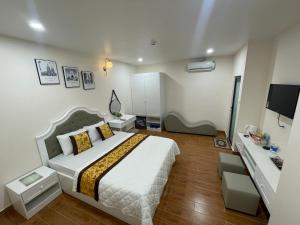a bedroom with a large bed and a desk at Thinh Gia Hotel in Bến Cát