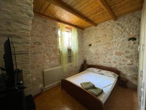 een slaapkamer met een bed in een stenen muur bij Find your peace in a traditional country house!! in Lagia