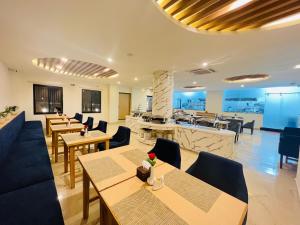 a restaurant with tables and chairs and a kitchen at Hotel Aikawa in Sauraha