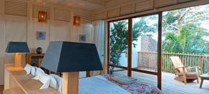 SantʼAnaにあるTribal Green Camp-Private Room 3のベッドルーム(ベッド1台付)、バルコニーが備わります。