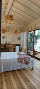 a bedroom with a large bed and a kitchen at Tribal Green Camp-Private Room 3 in Santana
