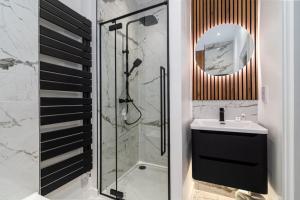 a bathroom with a shower and a sink and a mirror at GuestReady - Stunning Covent Garden 2BR Duplex in London