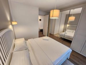 1 dormitorio con 1 cama blanca grande y espejo en Cloud9 Residence Great Apartments, en Bucarest