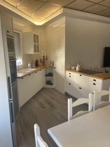 a kitchen with white cabinets and a table and chairs at Casita coqueta en Agua Amarga in Agua Amarga