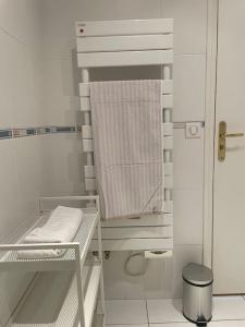 a small white bathroom with a towel on a shelf at Appartement avec vue exceptionnelle sur Biarritz in Biarritz