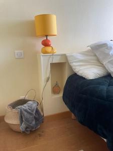 a bedroom with a bed and a lamp and a basket at Appartement avec vue exceptionnelle sur Biarritz in Biarritz