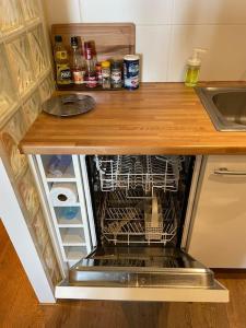an open dishwasher in a kitchen with a counter at Appartement avec vue exceptionnelle sur Biarritz in Biarritz