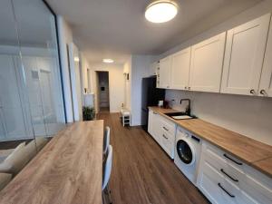 cocina con armarios blancos y encimera de madera en Cloud9 Residence Great Apartments, en Bucarest