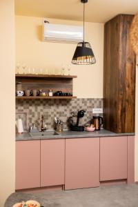 a kitchen with pink cabinets and a sink at Čista desetka! - sa garažnim mestom in Novi Sad