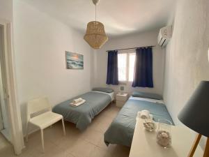 a room with two beds and a table and a chair at Casa del Mar 1 in Nerja