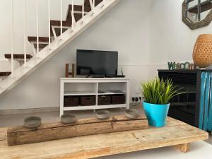 sala de estar con TV y mesa de centro de madera. en Casa del Mar 1, en Nerja