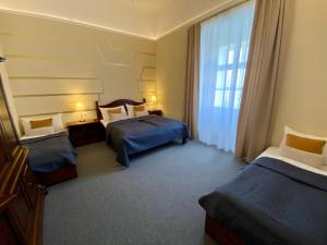 um quarto de hotel com duas camas e uma janela em Zámecký Hotel ANTON FLORIAN em Valtice