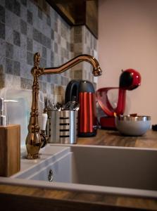 a kitchen sink with a copper faucet at Čista desetka! - sa garažnim mestom in Novi Sad