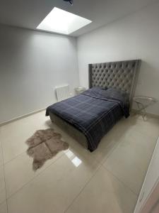1 dormitorio con 1 cama con manta azul y alfombra en Cosy house, en Le Petit-Quevilly