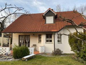 een wit huis met een oranje dak bij Ferienhaus Brühler in Maierhof