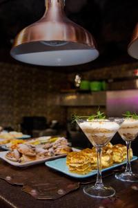 een tafel met twee cocktails en borden eten bij Boutique Spa Casino Hotel Lybid Plaza in Chmelnytsky