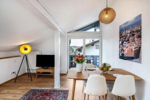 a dining room with a table and chairs and a television at Wohnung am See in Gmund am Tegernsee