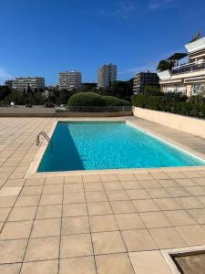 - une piscine d'eau bleue dans un bâtiment dans l'établissement Superbe appartement vue imprenable sur la mer proche Monaco, à Roquebrune-Cap-Martin