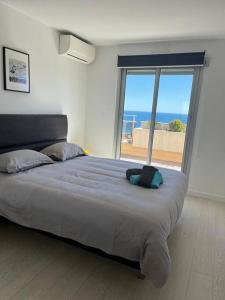- une chambre avec un grand lit et une vue sur l'océan dans l'établissement Superbe appartement vue imprenable sur la mer proche Monaco, à Roquebrune-Cap-Martin