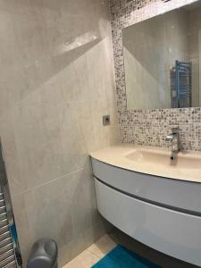 La salle de bains est pourvue d'un lavabo et d'un miroir. dans l'établissement Superbe appartement vue imprenable sur la mer proche Monaco, à Roquebrune-Cap-Martin