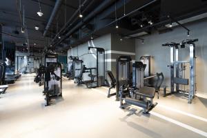 un gimnasio con filas de cintas de correr y máquinas en Marquise Square - 2Br Apartment - Allsopp&Allsopp, en Dubái
