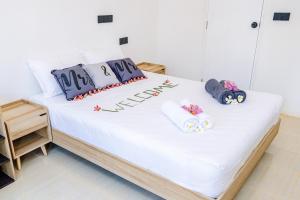 Una cama con sábanas blancas y almohadas azules. en Ahiva Village, en Isla Fulhadhoo