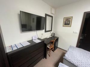 1 dormitorio con escritorio, TV y cama en Apartmán Ateliér en Kadaň