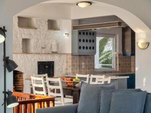 a kitchen with a blue couch and a table and chairs at Villa Nikolitsa with private beach in Megara