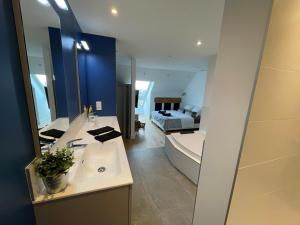 La salle de bains est pourvue d'un lavabo, d'une baignoire et d'un lit. dans l'établissement Chambre proche centre avec petit déjeuner, à Fontaine-lès-Dijon