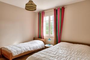 a bedroom with two beds and a window at Vacances en famille ou entre amis à Loctudy in Loctudy