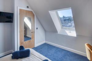 Habitación con cama, espejo y ventana en Ocean Cabins No 11 At The Square - Saundersfoot, en Saundersfoot