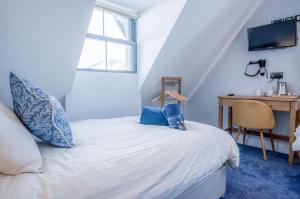 a bedroom with a bed with a desk and a window at Ocean Cabins No 10 At The Square - Saundersfoot in Saundersfoot