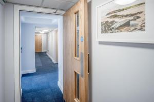 a hallway with a door and a painting on the wall at Ocean Cabins No 13 At The Square - Saundersfoot in Saundersfoot