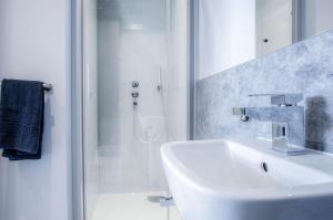 a white bathroom with a sink and a shower at Ocean Cabins No 14 At The Square - Saundersfoot in Saundersfoot