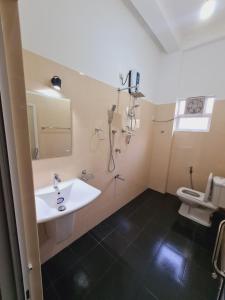 a bathroom with a sink and a toilet at Jungle Lodge in Udawalawe