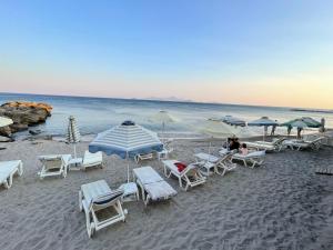 a group of chairs and umbrellas on a beach at Efi studios in Kardamaina