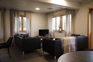 ein Wohnzimmer mit Stühlen, einem Tisch und einem TV in der Unterkunft Orsa Grönklitt in Orsa